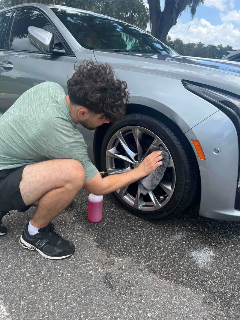 Mobile detailer rinsing a red pickup