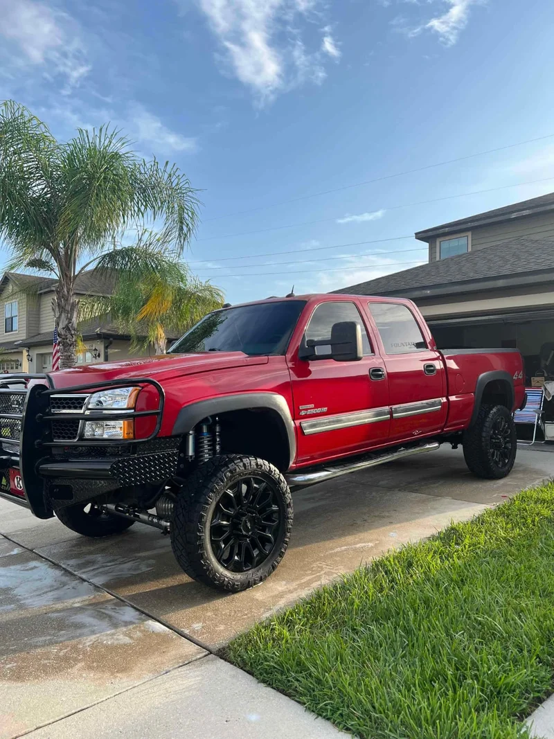 Detailer foaming a red pickup truck