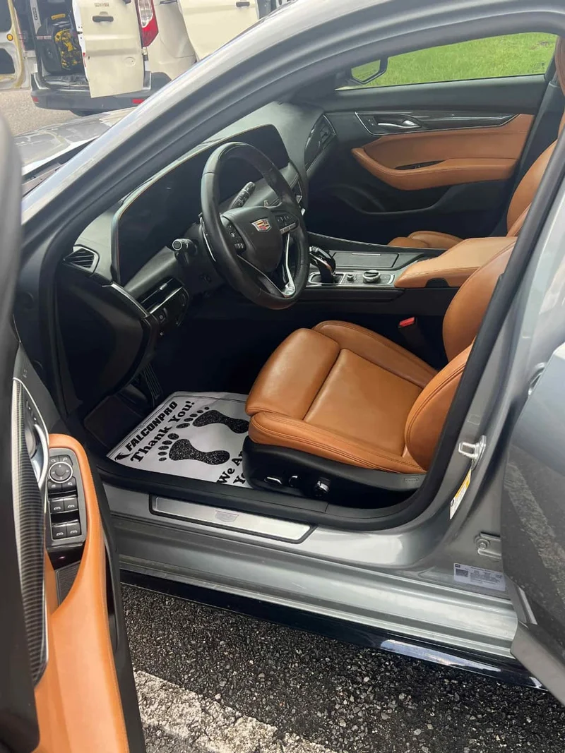 Detailer cleaning a silver Cadillac