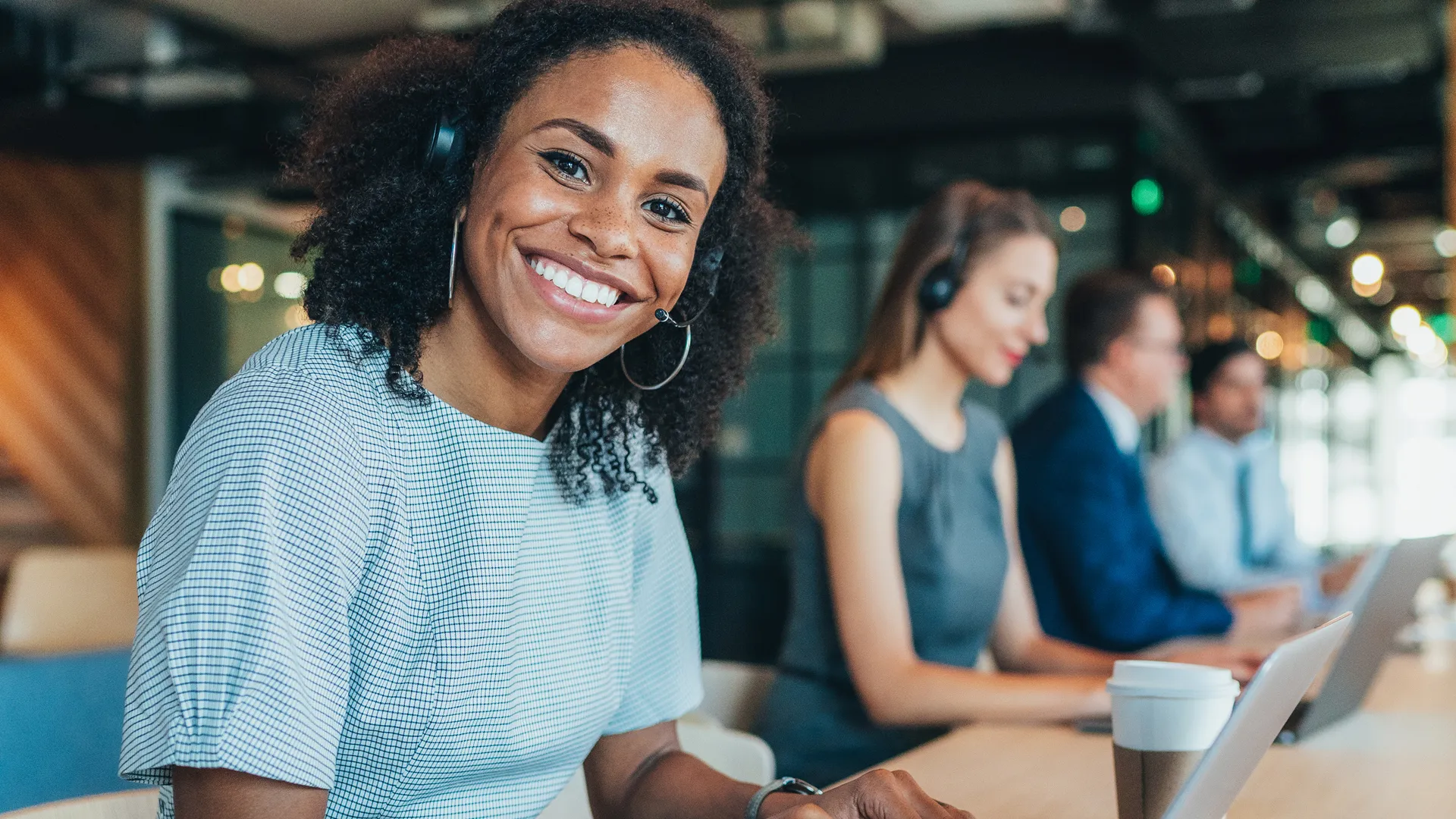 A friendly female customer support officer with a headset smiling