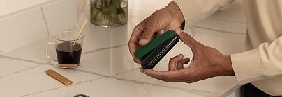 Hands opening green Ploom AURA device-5