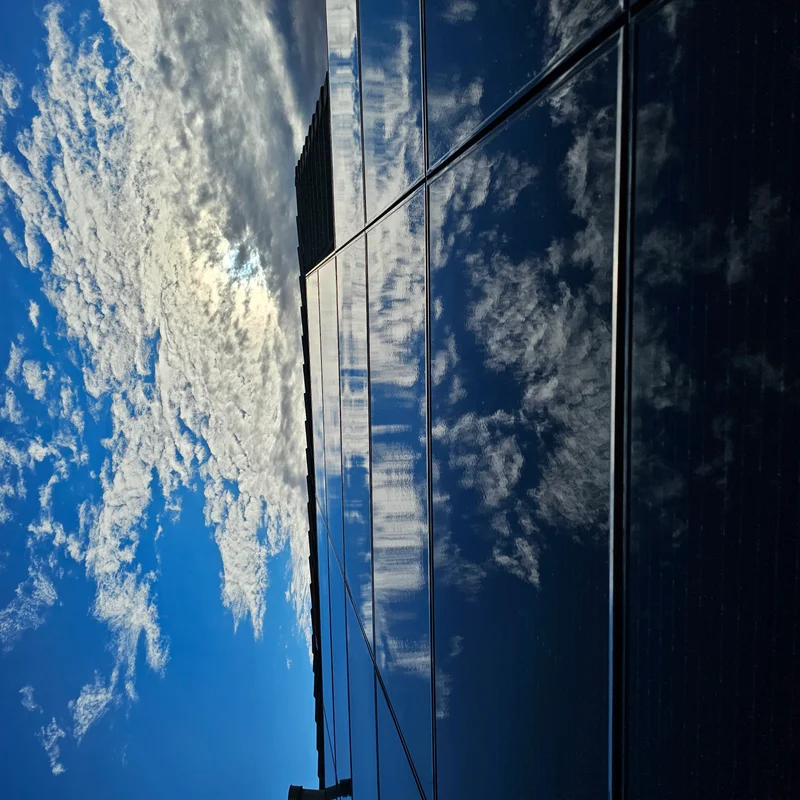 Rooftop solar panels reflecting a blue sky