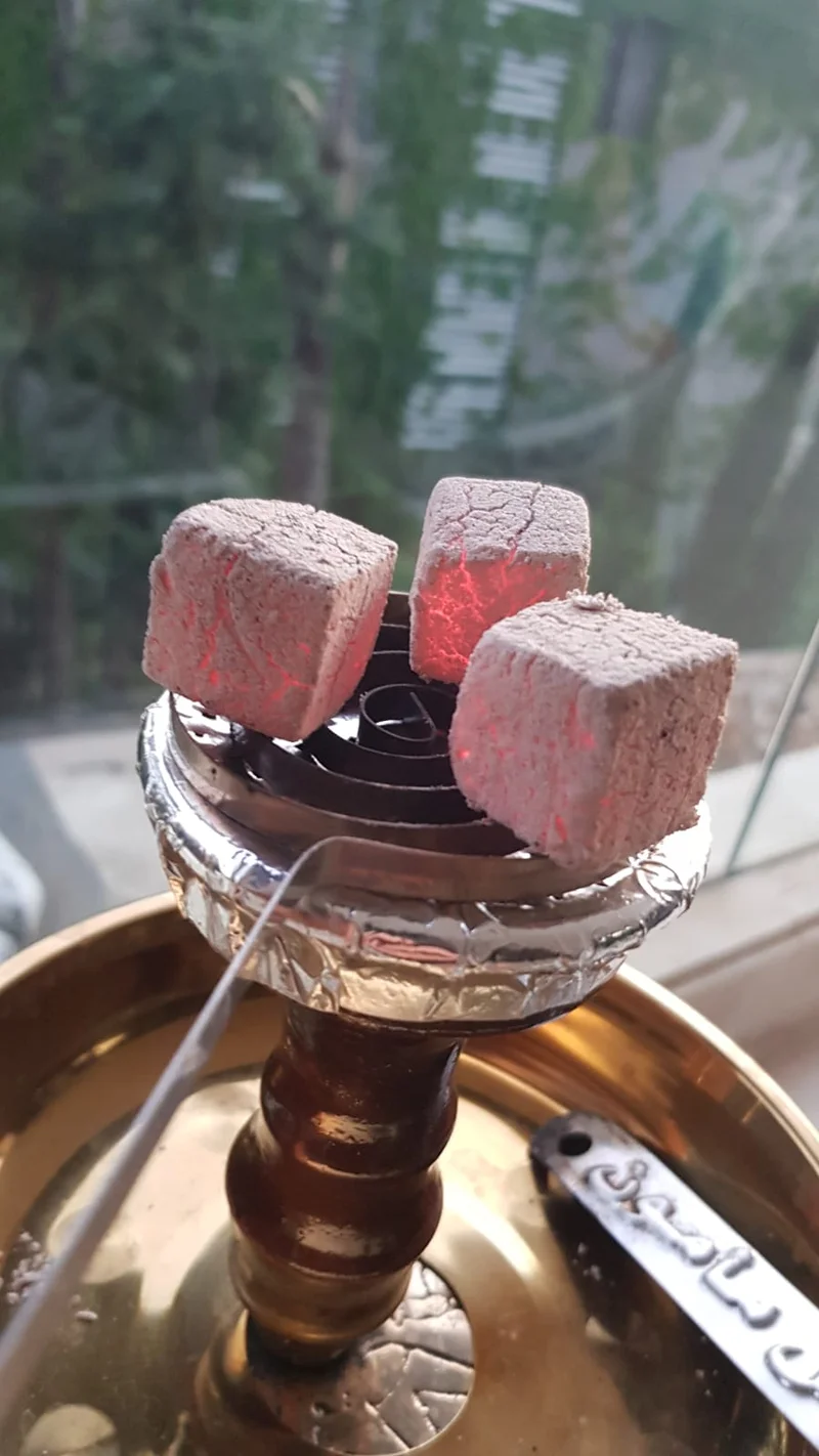 Go Chicha coconut charcoal burning with bright red glow in shisha bowl