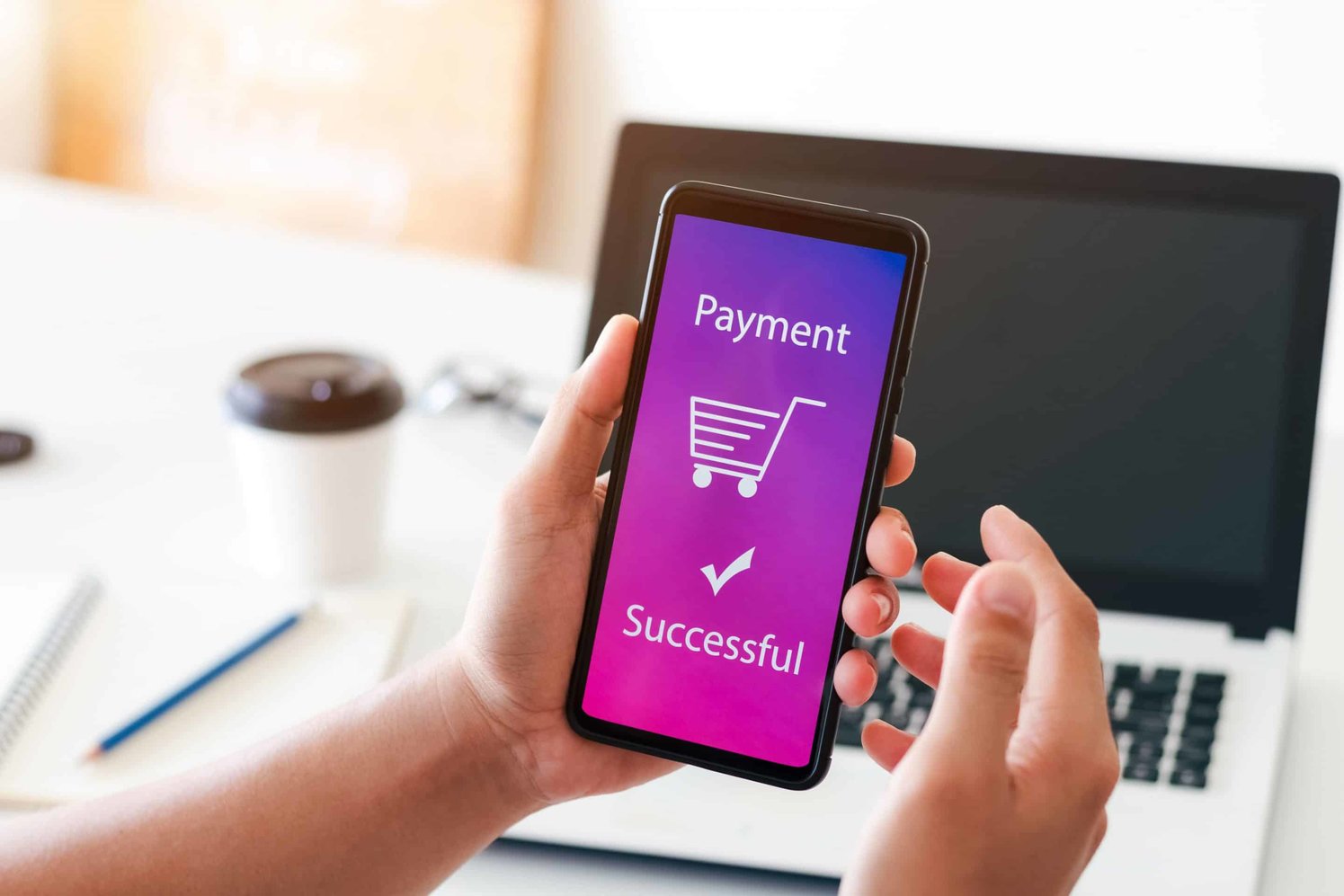 Person holding the phone with a purple screen that shows the message "Payment Successful"