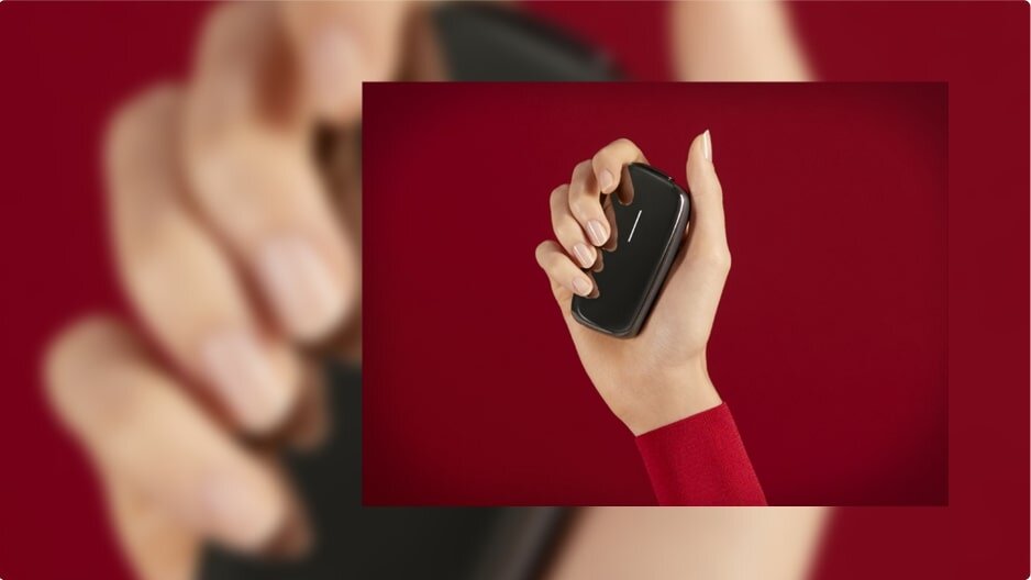 Displayed is a Ploom device held in a hand.