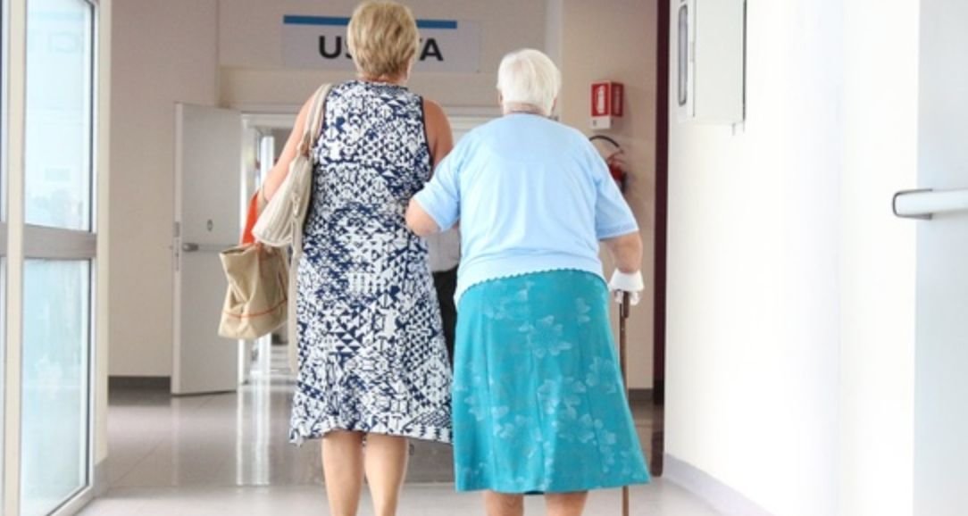 Two people walk in a hospital hallway