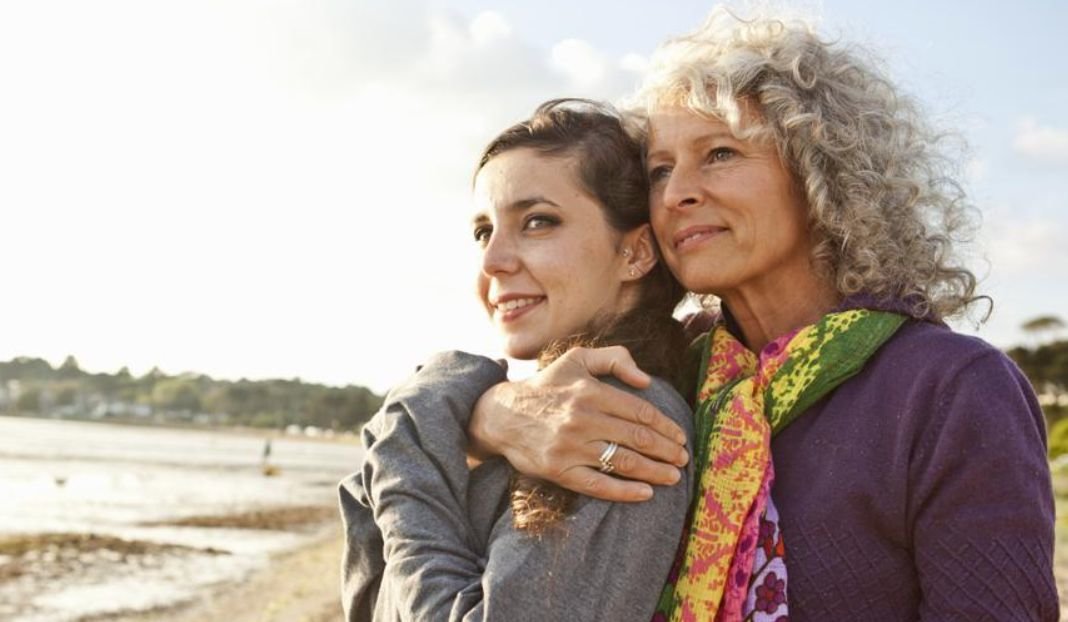 An older woman hugs a younger woman