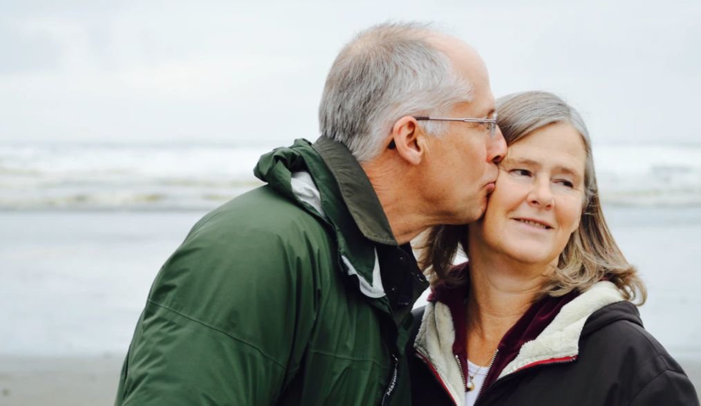 A man kisses a woman on the cheek