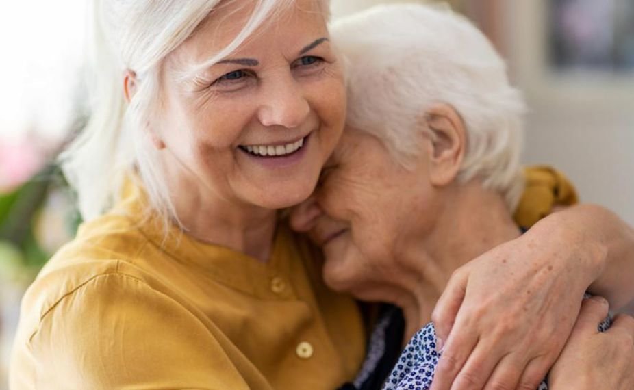 Two women embrace while smiling