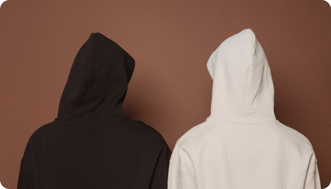 Two people viewed from the back, one wearing a black hoodie and the other one wearing a white hoodie