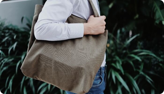 Person with a brown tote bag over their shoulder