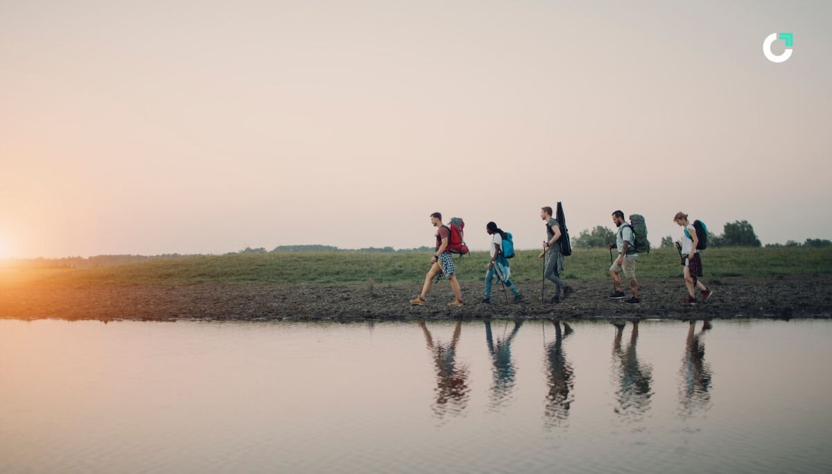 Team of people hiking next to a river