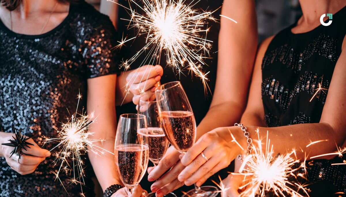 People holding sparklers and glasses of wine at a company holiday party