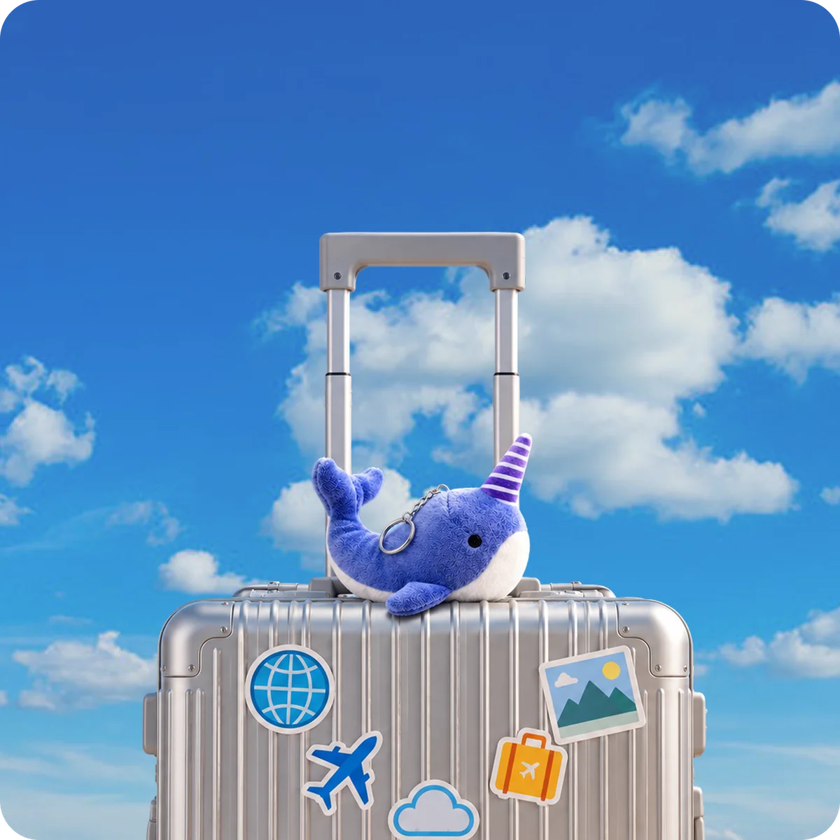 Event merchandise packed in a suitcase, including a purple narwhal plushie and travel accessories