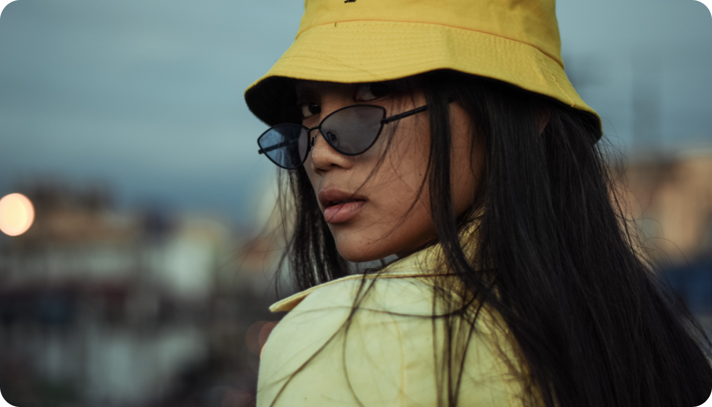 Young asian woman with glasses wearing a bright yellow bucket hat