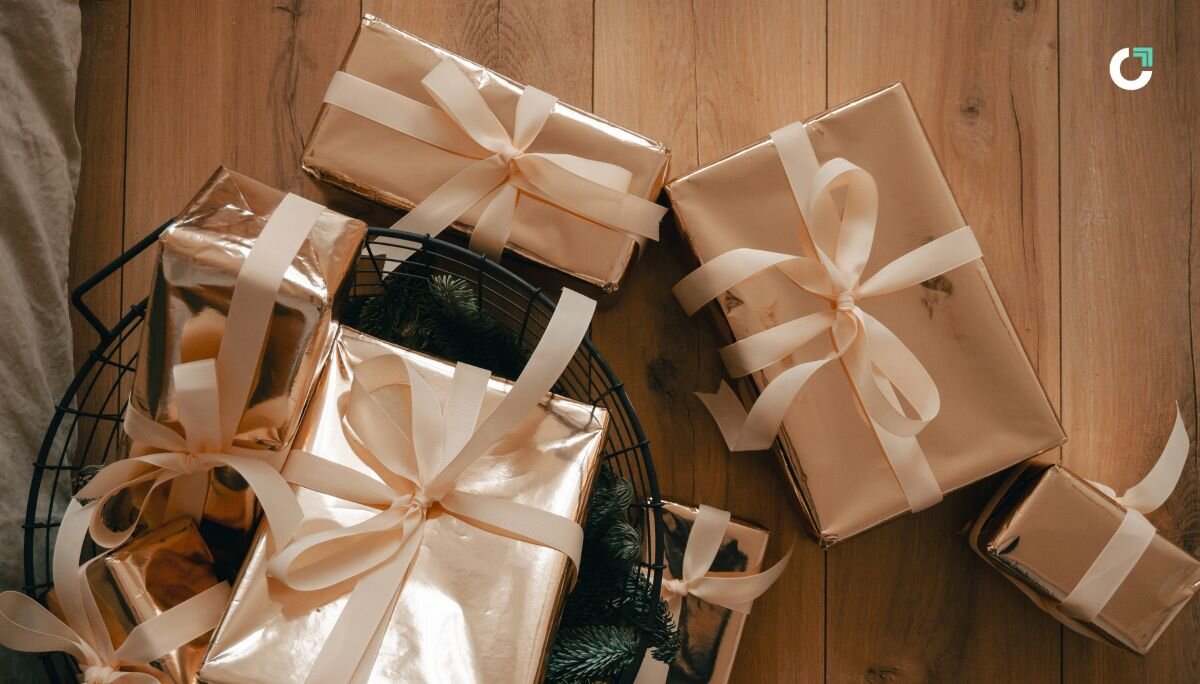 Elegant holiday gift boxes with satin ribbons on a wooden floor — modern corporate gifting inspiration for 2025.