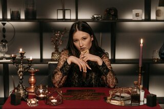 a woman sitting at a table ready to do a tarot reading