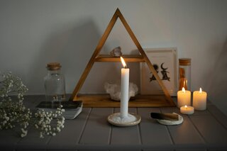a candle burning in front of a triangular altar