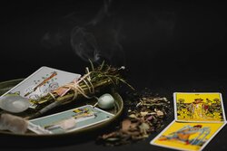 tarot cards with burning sage and gems