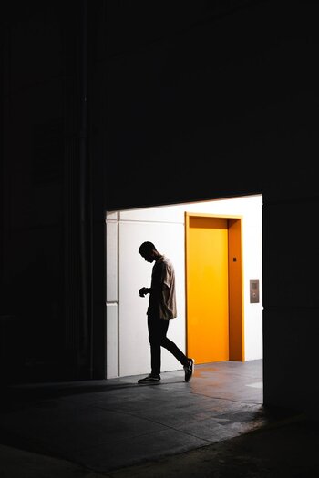 a man standing in the distance near an orange door