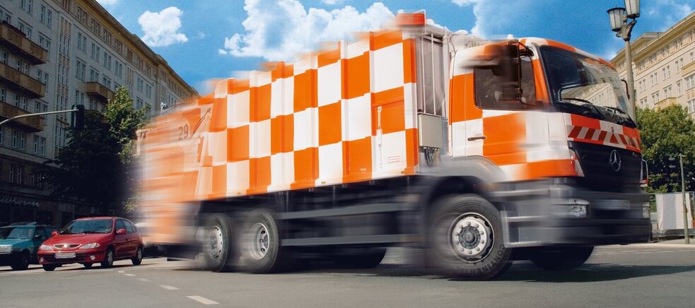 Muster aus schwarz-orange karierten Socken und Müllauto aus Klemmbausteine