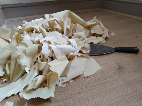 Zerrissene Papierstücke auf einem Holzboden