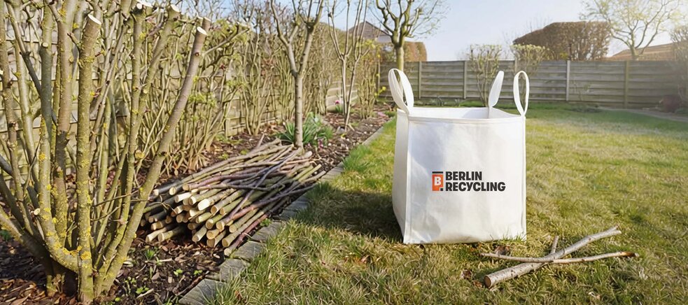 Zwei Müllwerker in orangefarbener Schutzkleidung schieben Mülltonnen auf einem Bürgersteig neben einem Müllfahrzeug in einer städtischen Straße.