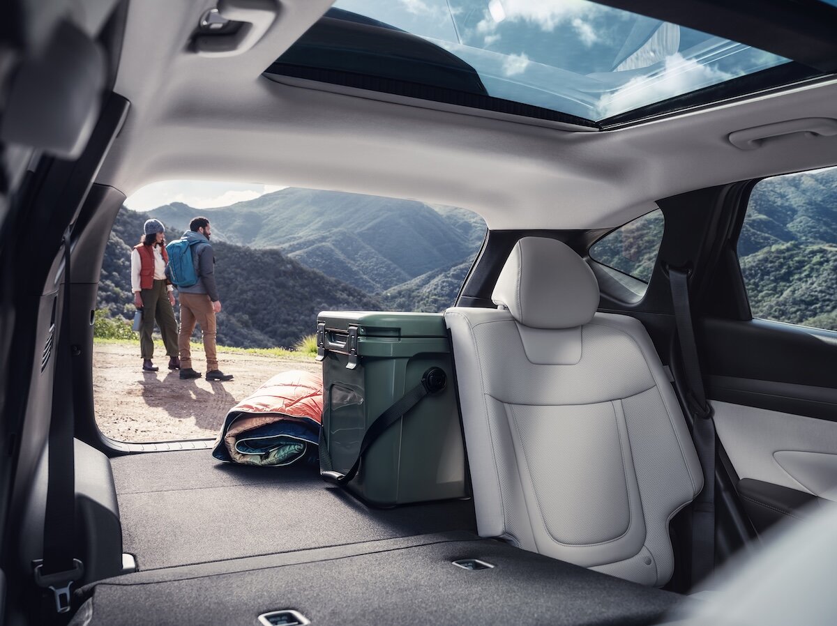 2026 Hyundai Tucson rear seat and boot with people admiring scenic view