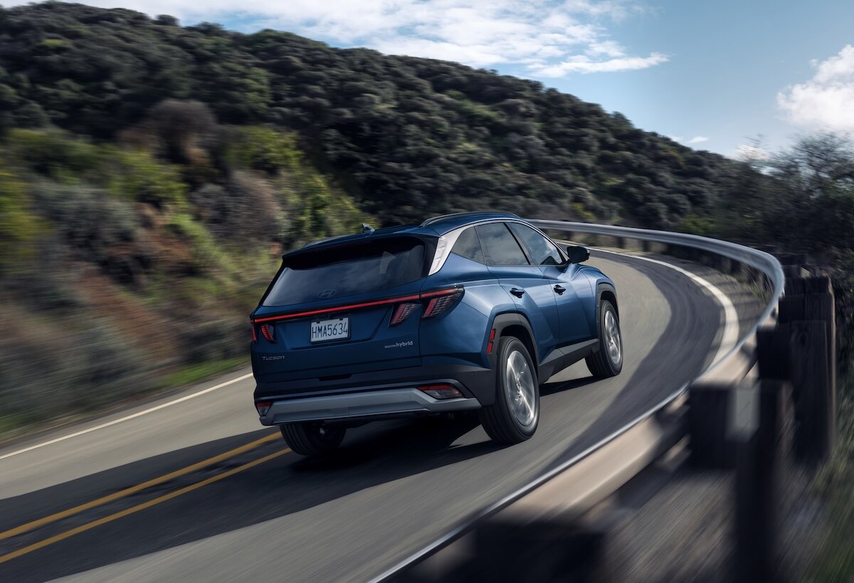 2026 Hyundai Tucson driving on mountain road, rear view
