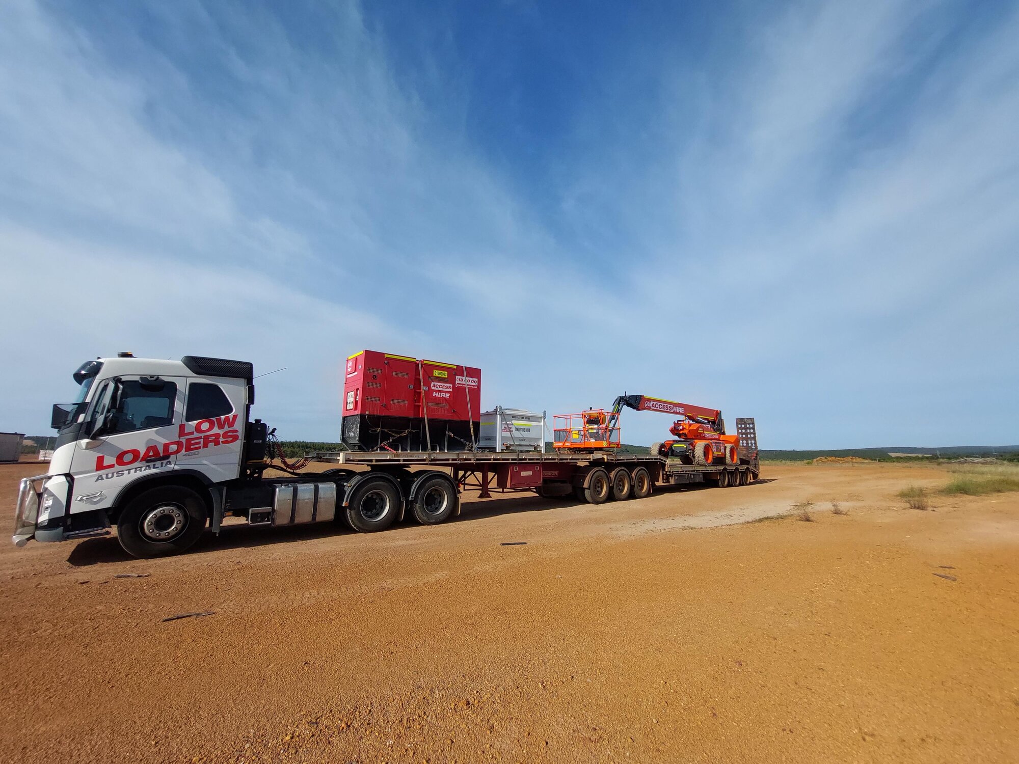 Low loader transporting a generator and boom lift to a worksite near Collie, Western Australia.
