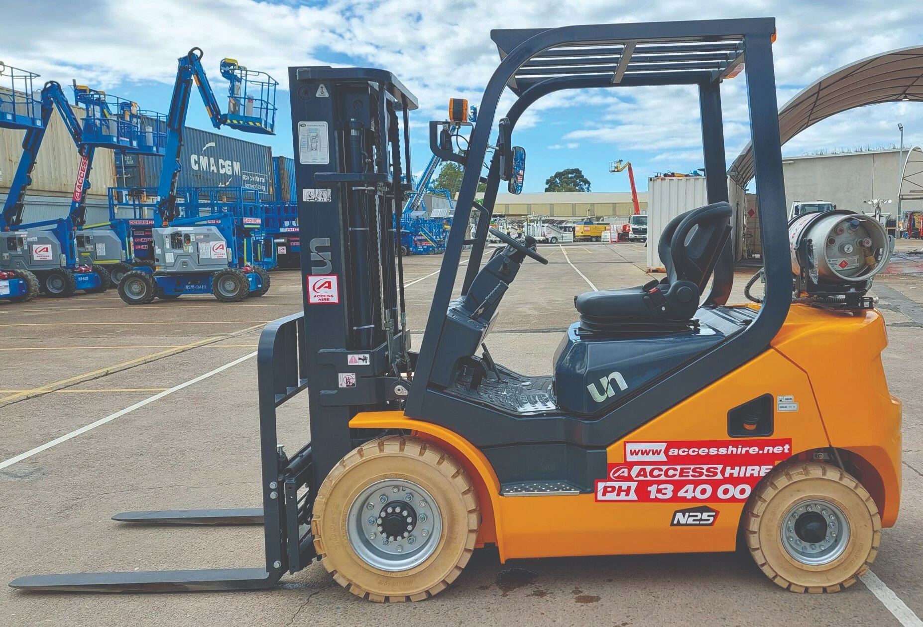 UN 2.5-tonne LPG and petrol forklift displayed at the Access Hire equipment yard with boom lifts in the background