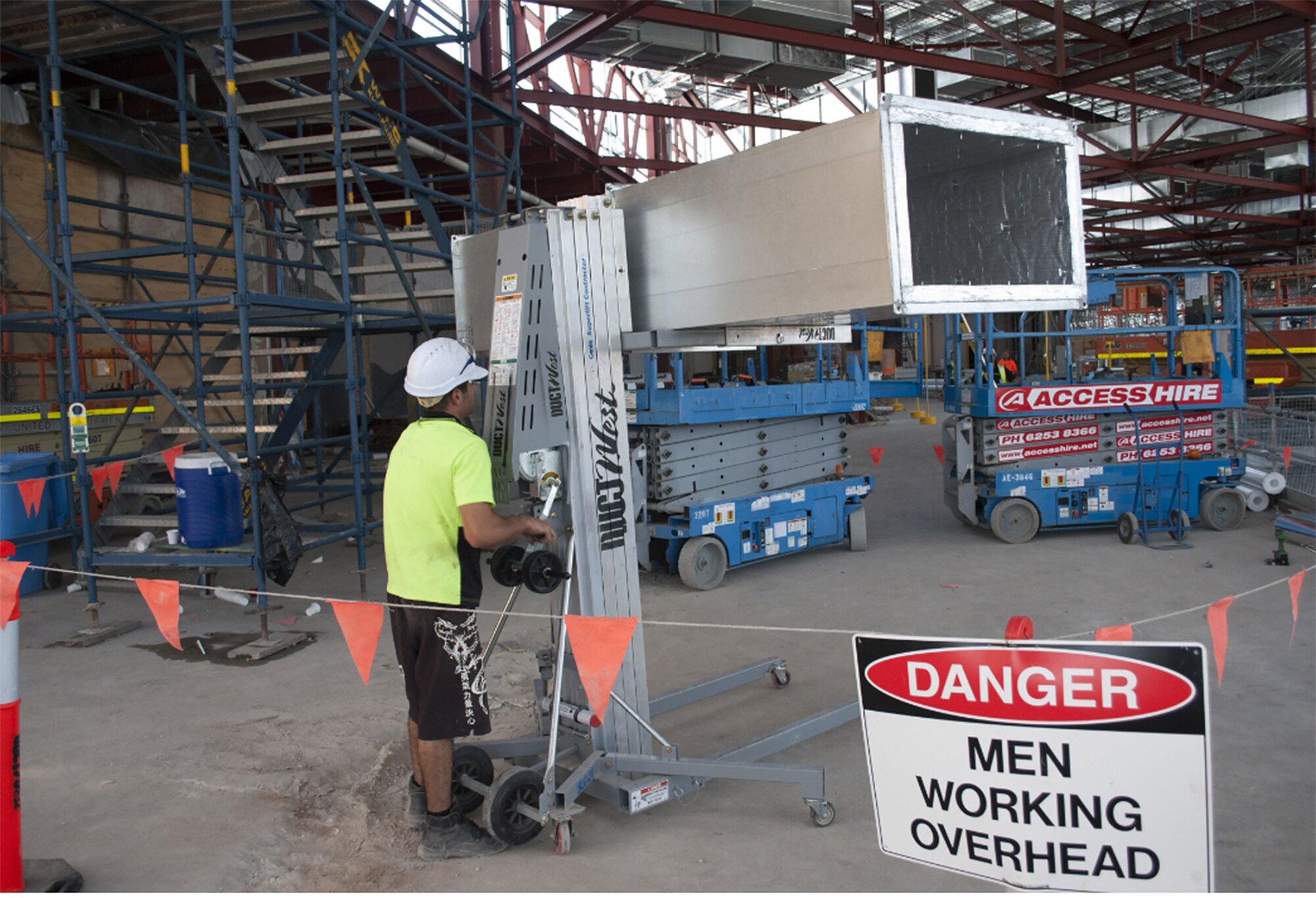 Material lift being used alongside Access Hire scissor lifts on an active construction site.