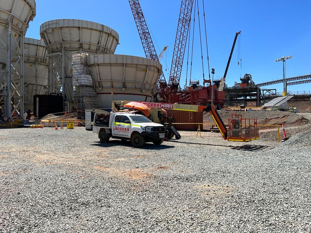 Access Hire boom lift and service vehicle supporting equipment maintenance at a large industrial construction site.