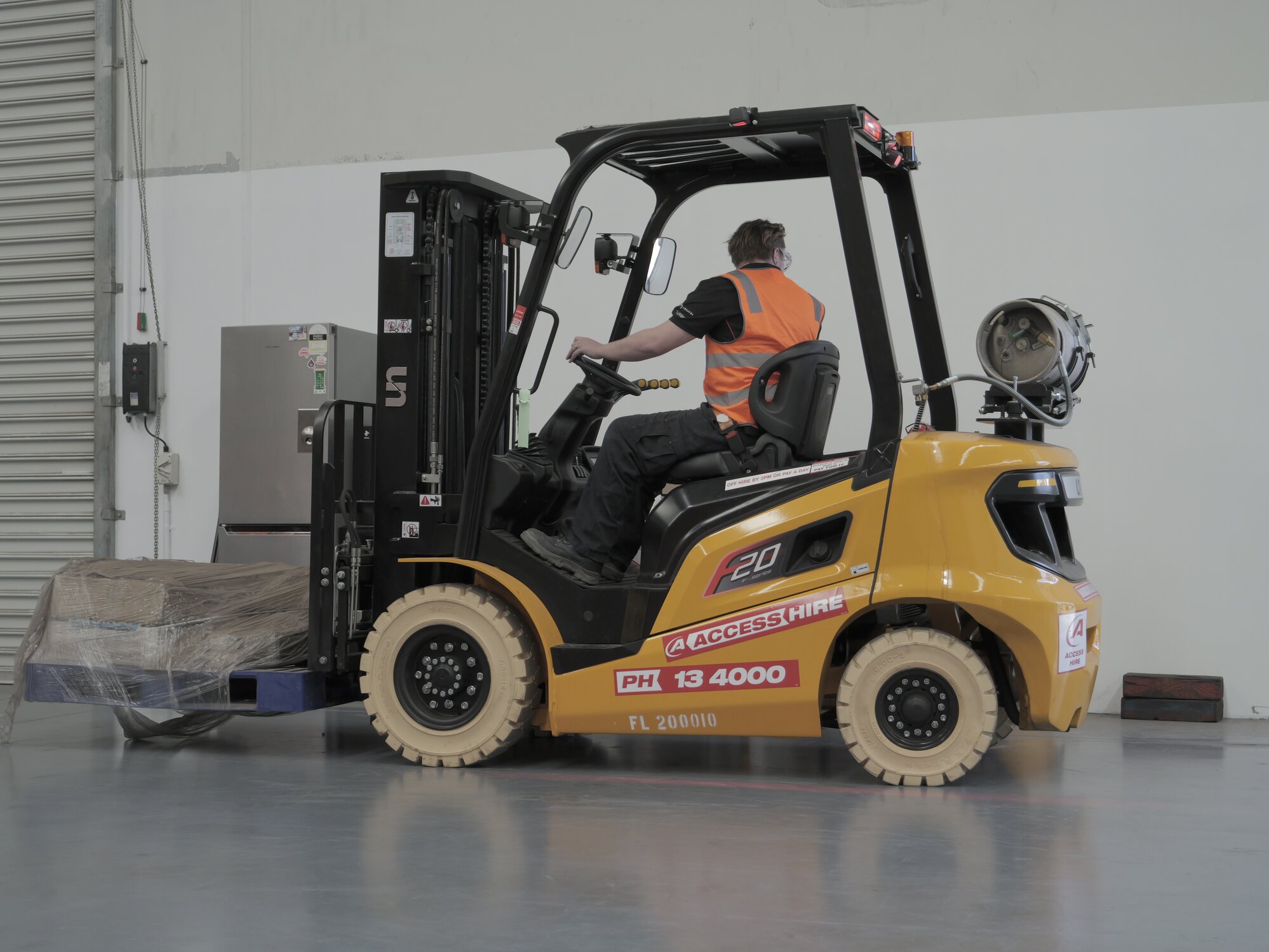 Access Hire forklift transporting a pallet inside an industrial warehouse