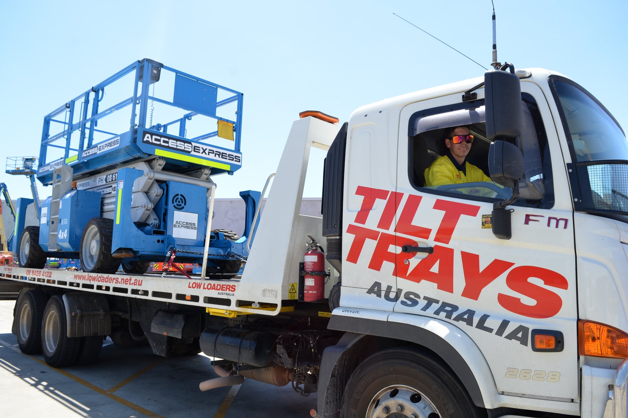 Truck & Trailer Rentals tilt tray transporting an Access Express rough terrain scissor lift in Canning Vale, Western Australia.