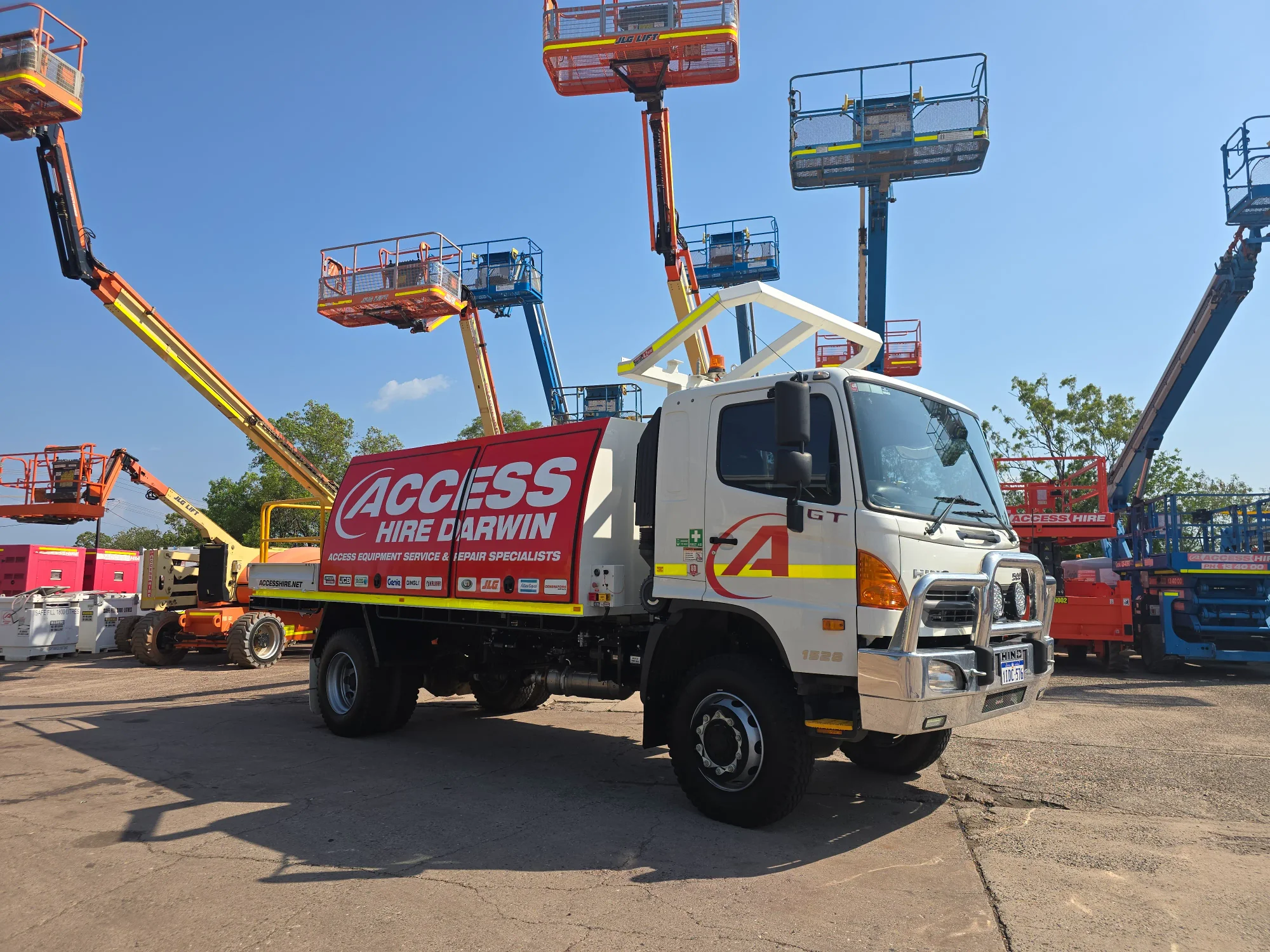 Darwin Access Hire service truck positioned among boom lifts in an equipment yard