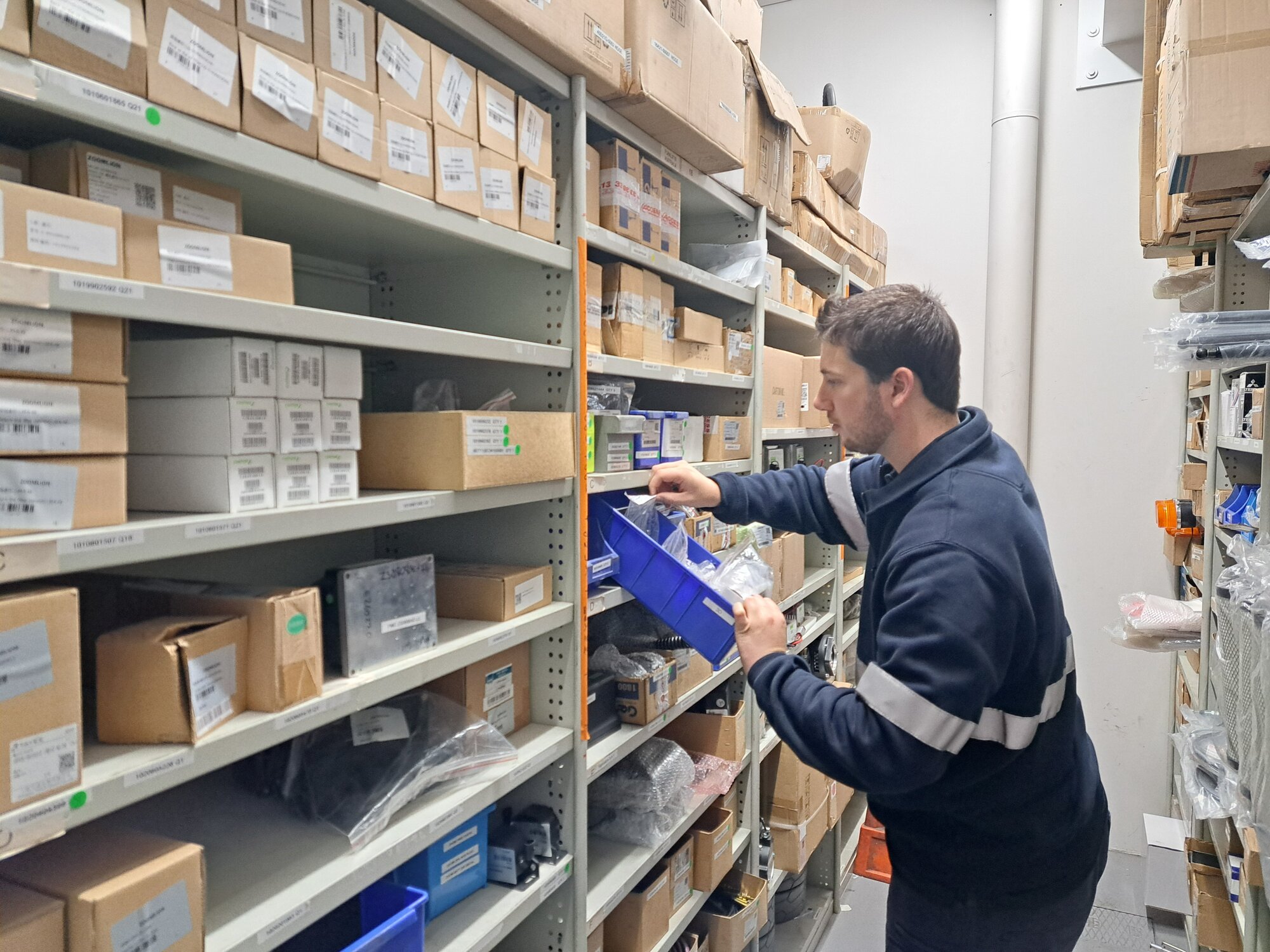 Access Services Group team member selecting parts from a warehouse inventory for equipment maintenance.