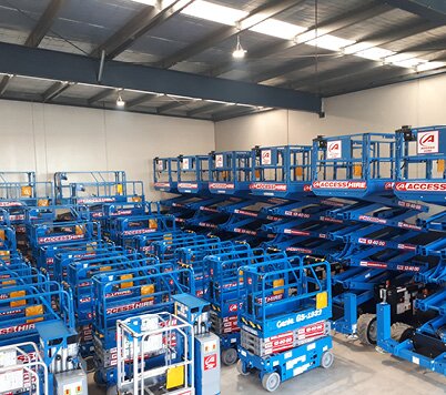 Electric scissor lifts stored inside the Access Hire Melbourne workshop and fleet facility