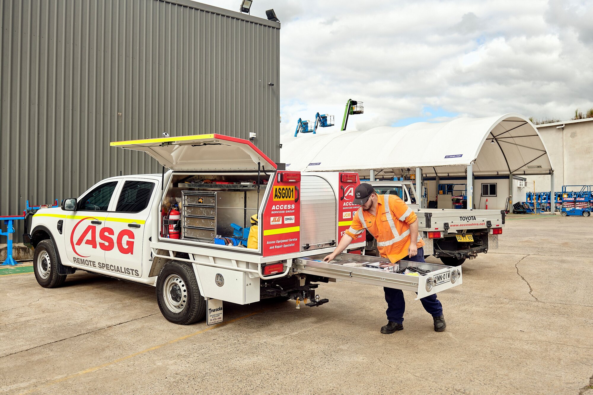 Technician accessing tools from a field service vehicle while preparing equipment maintenance.