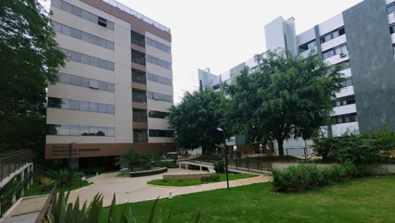 Ildefonso: Homem em frente às geladeiras de um bar, sorrindo para a câmera, vestindo camisa e boné verdes.