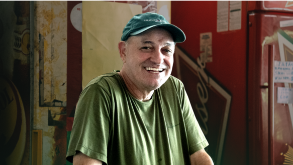 Cliente da Lemon, dentro do Bar do Dé, em Minas Gerais, vestindo camisa e boné verde, sorrindo