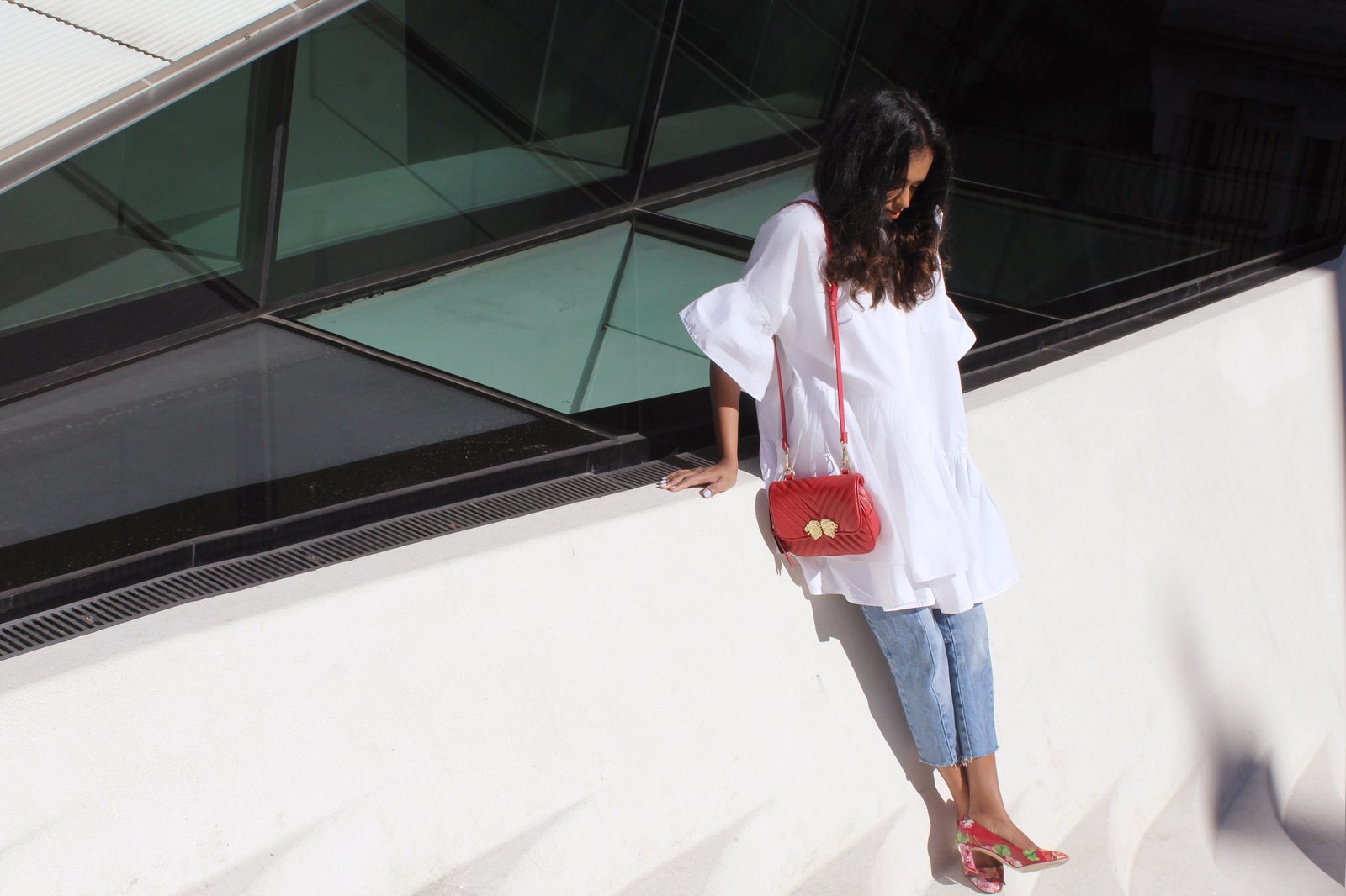 Sachini wearing a white dress, red Gucci shoes and Levi's jeans