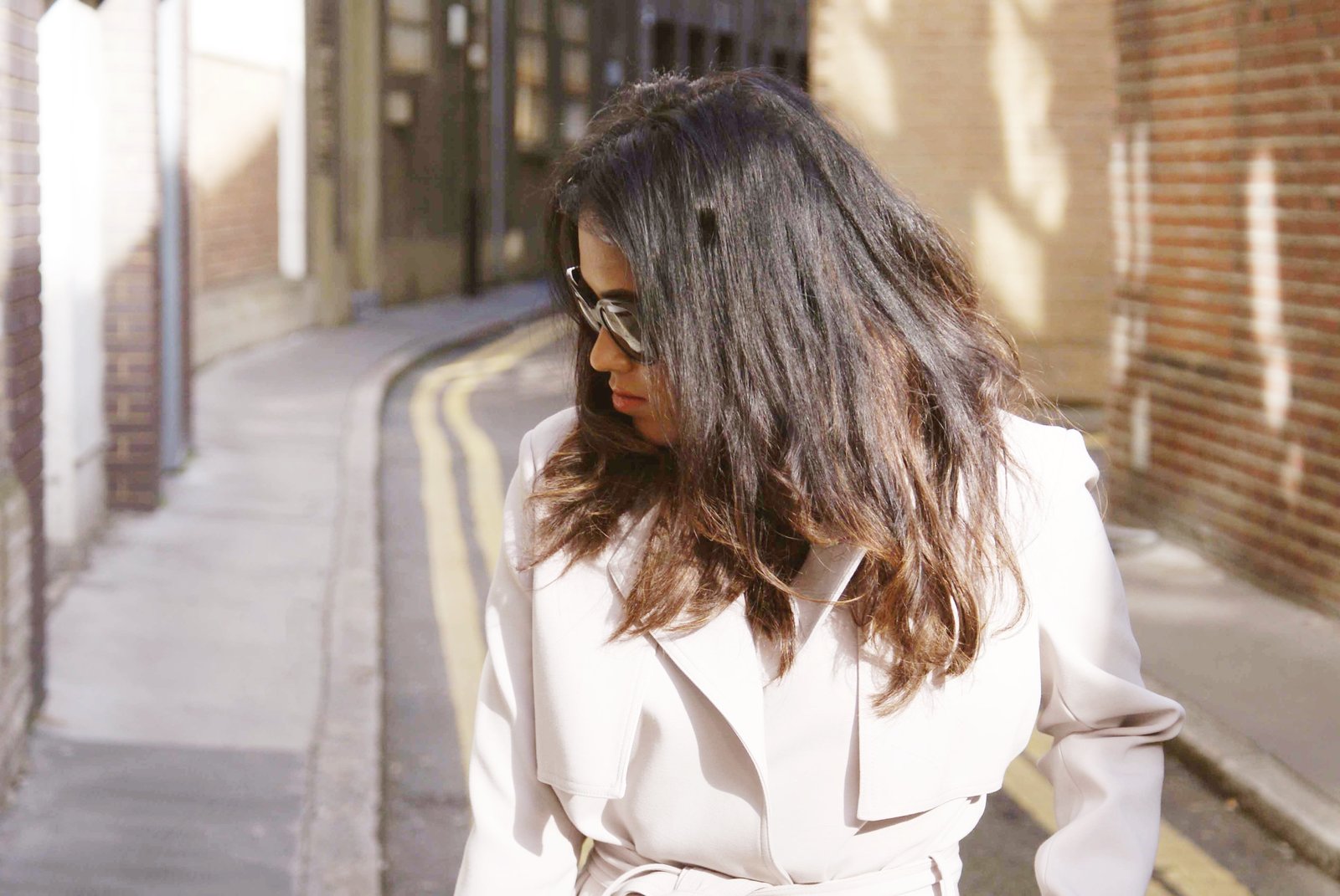 Sachini wearing a beige trench coat