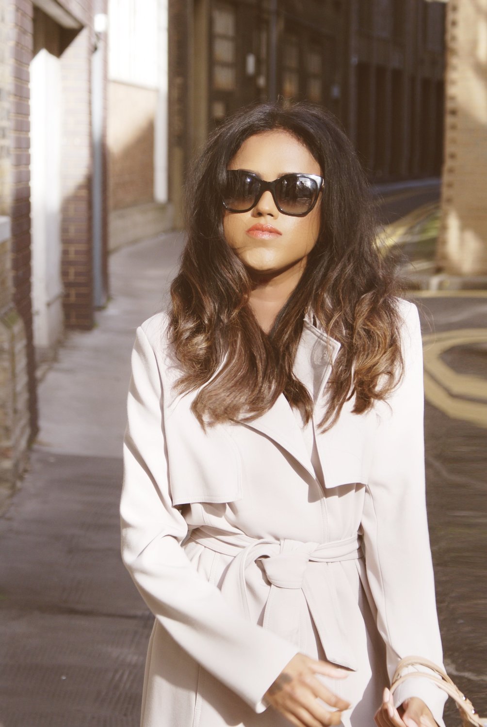 Sachini wearing a beige trench coat