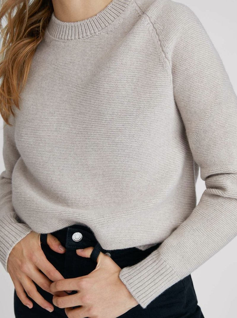 Close up of a model wearing beige Sheep Inc knitwear
