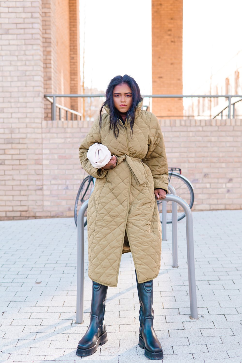 Sachini wearing a brown & Other Stories coat and black boots