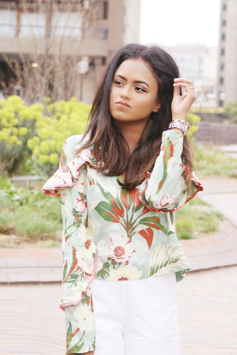 Close up of Sachini wearing a floral top in an urban garden