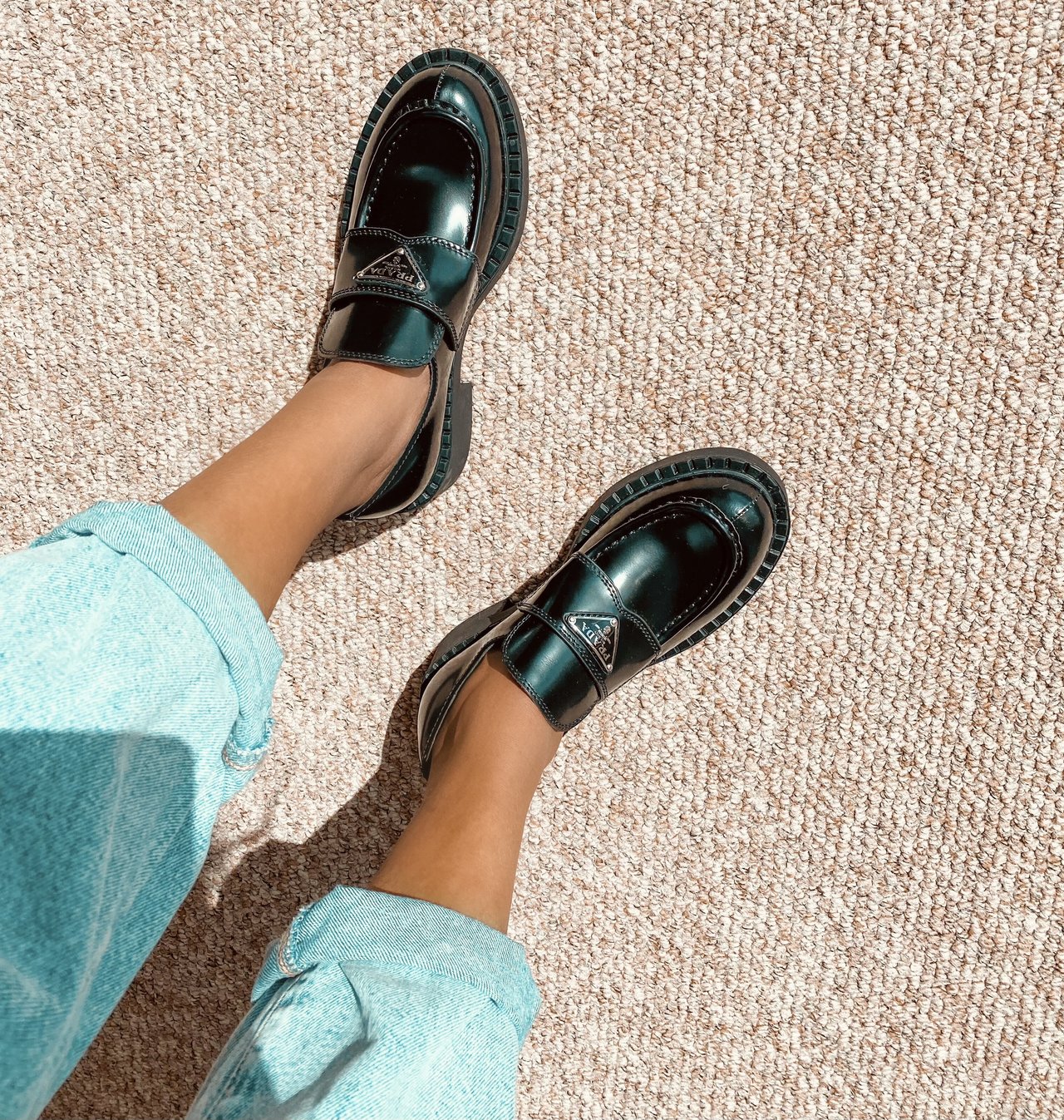 Close up of Sachini wearing black Prada loafers