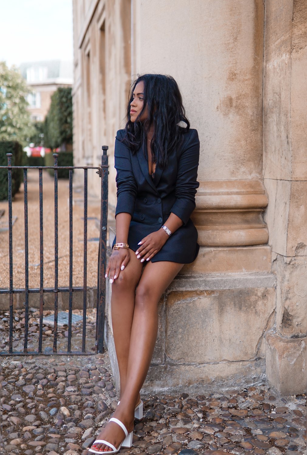 Sachini wearing a black Saint and Sofia blazer, black shorts holding a black Celine bag