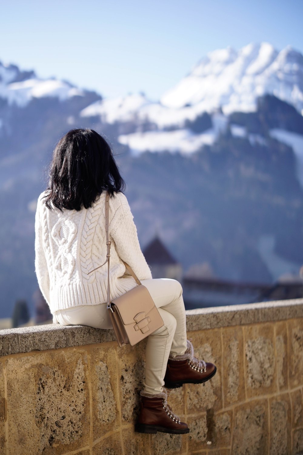 Sachini wearing white looking at a snowy mountain